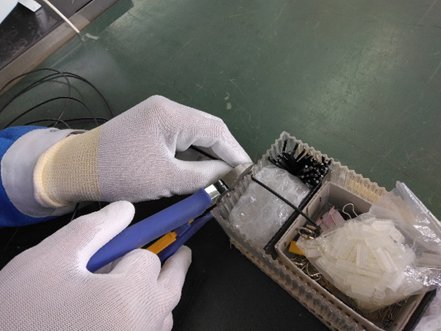 改善前：ニッパーでバインド線を手作業でカットする様子